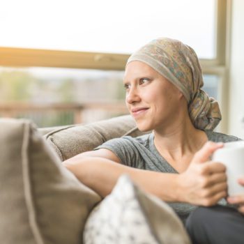 Ethnic young adult female cancer patient sipping tea